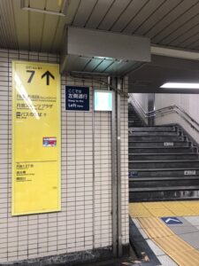 駅の7番出口表示と、地上へ上がる階段を写した写真。